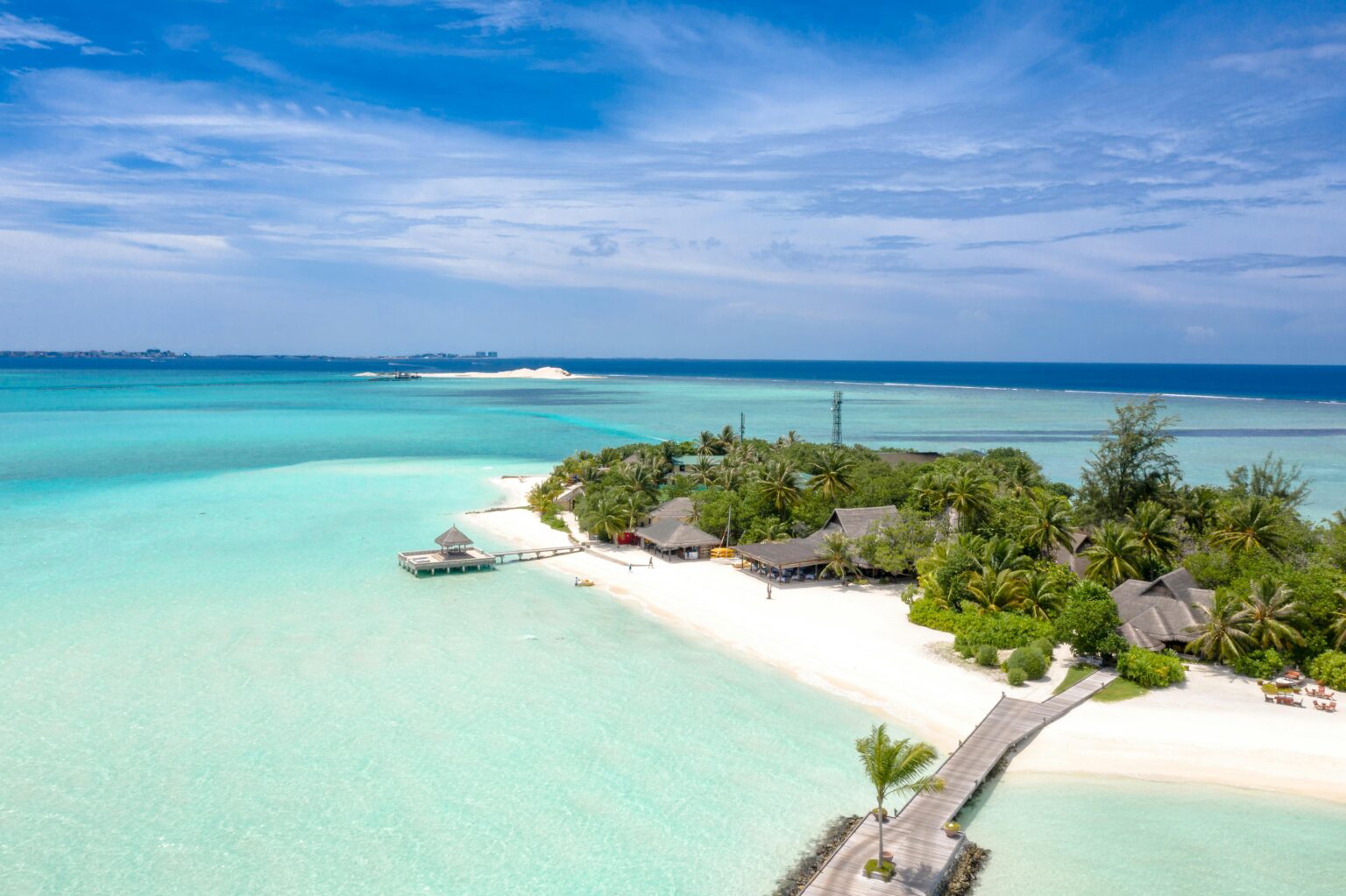 Aerial view of an idyllic tropical island resort with turquoise waters and sandy beaches.